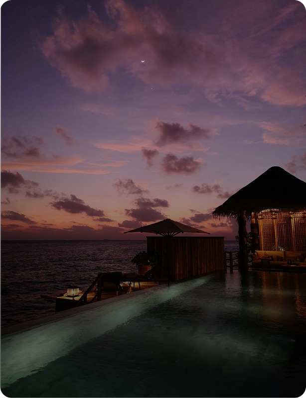 Honeymoon couple enjoying romantic sunset in Maldives over turquoise waters and white sandy beach